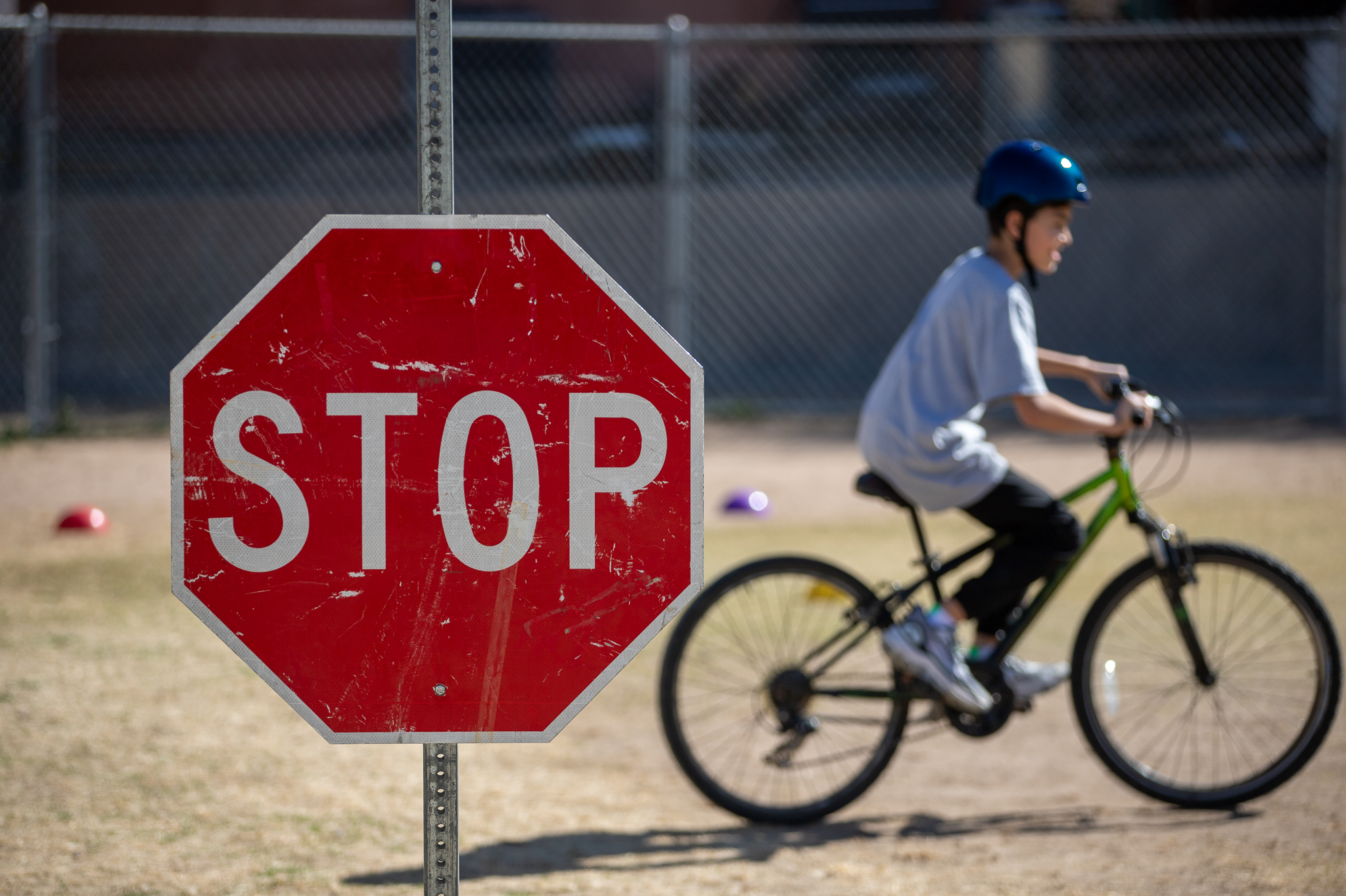 A boy rides his bike past a stop sign