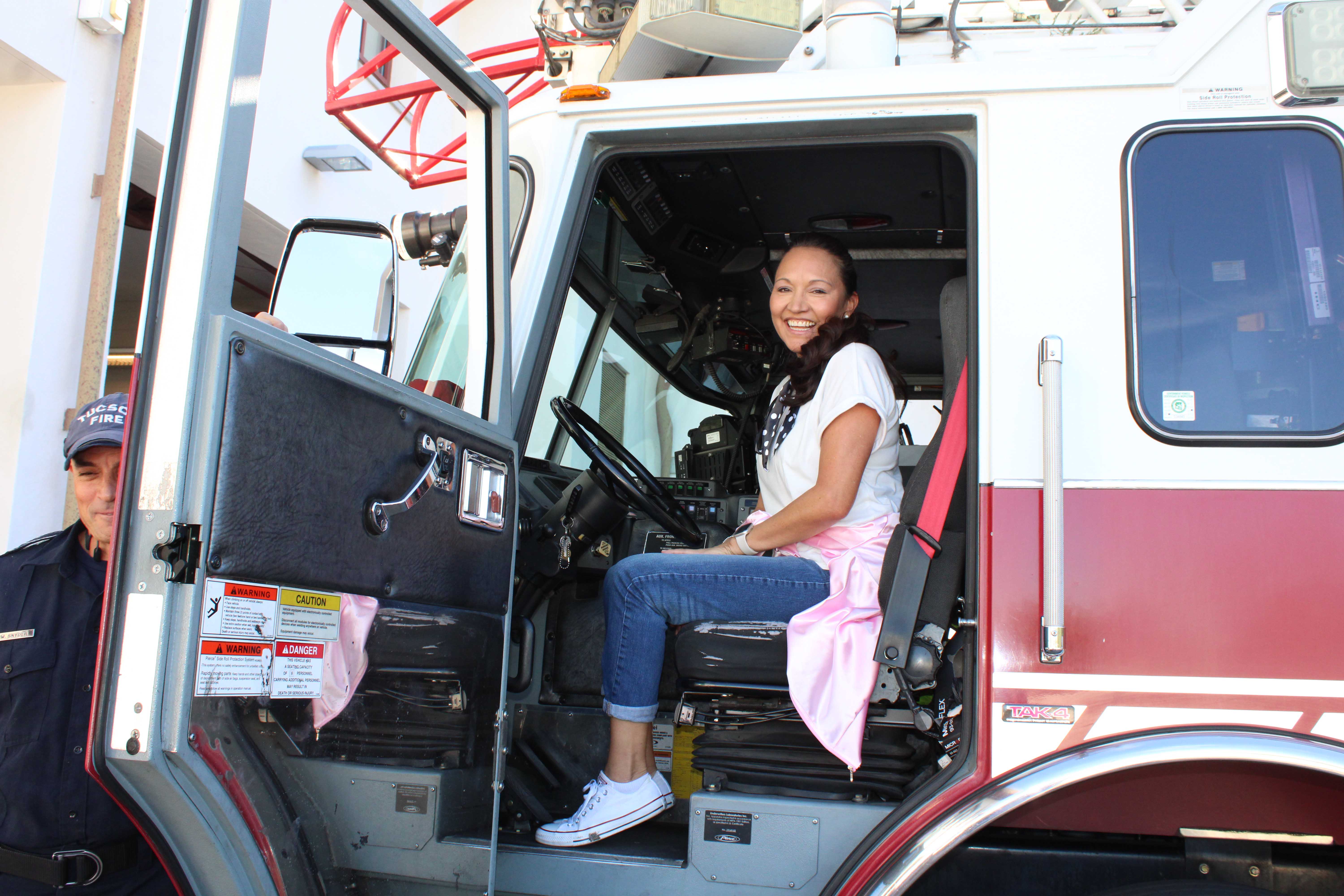 A teacher smiles inside a fire truck