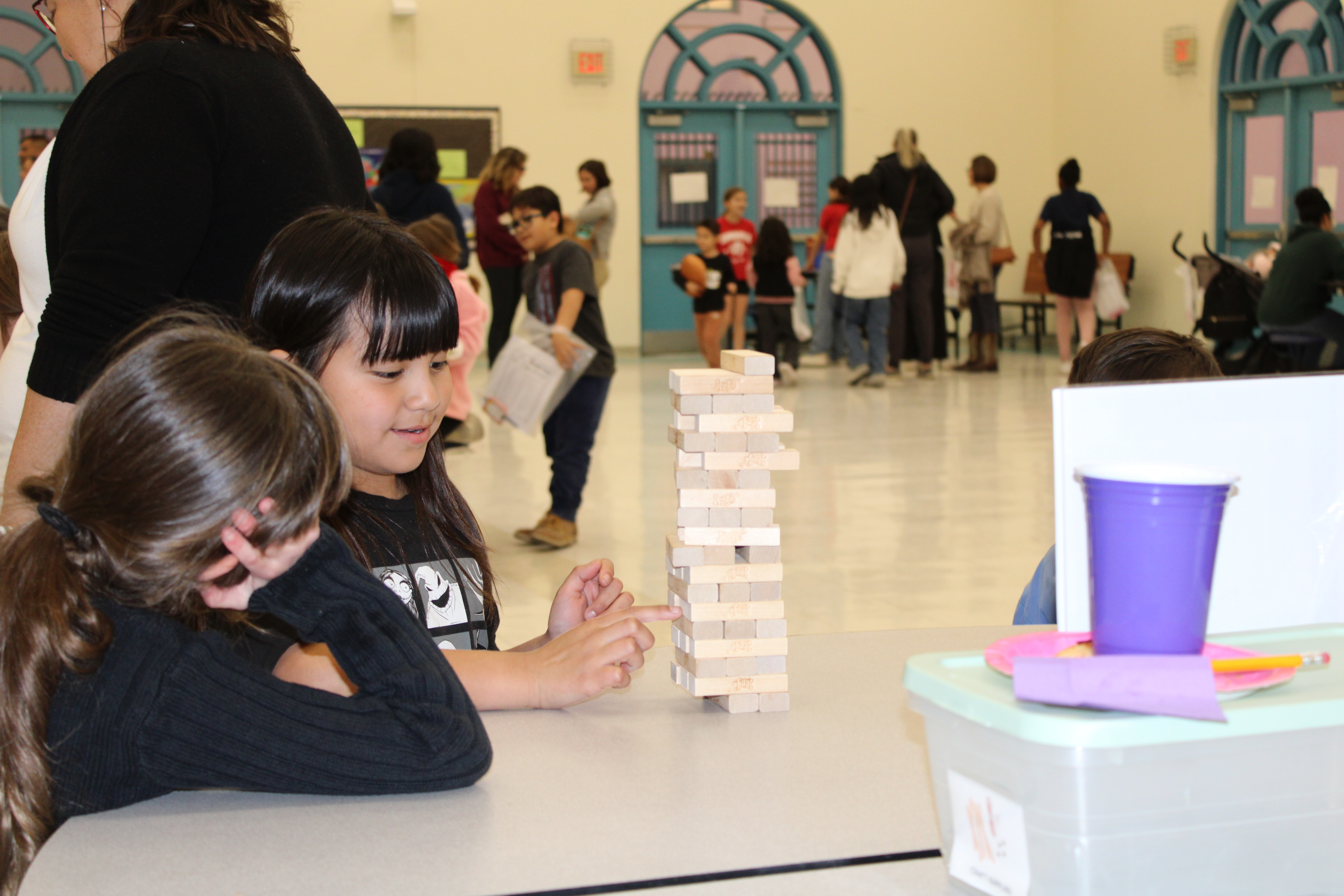 Two girls play a game of Jenga