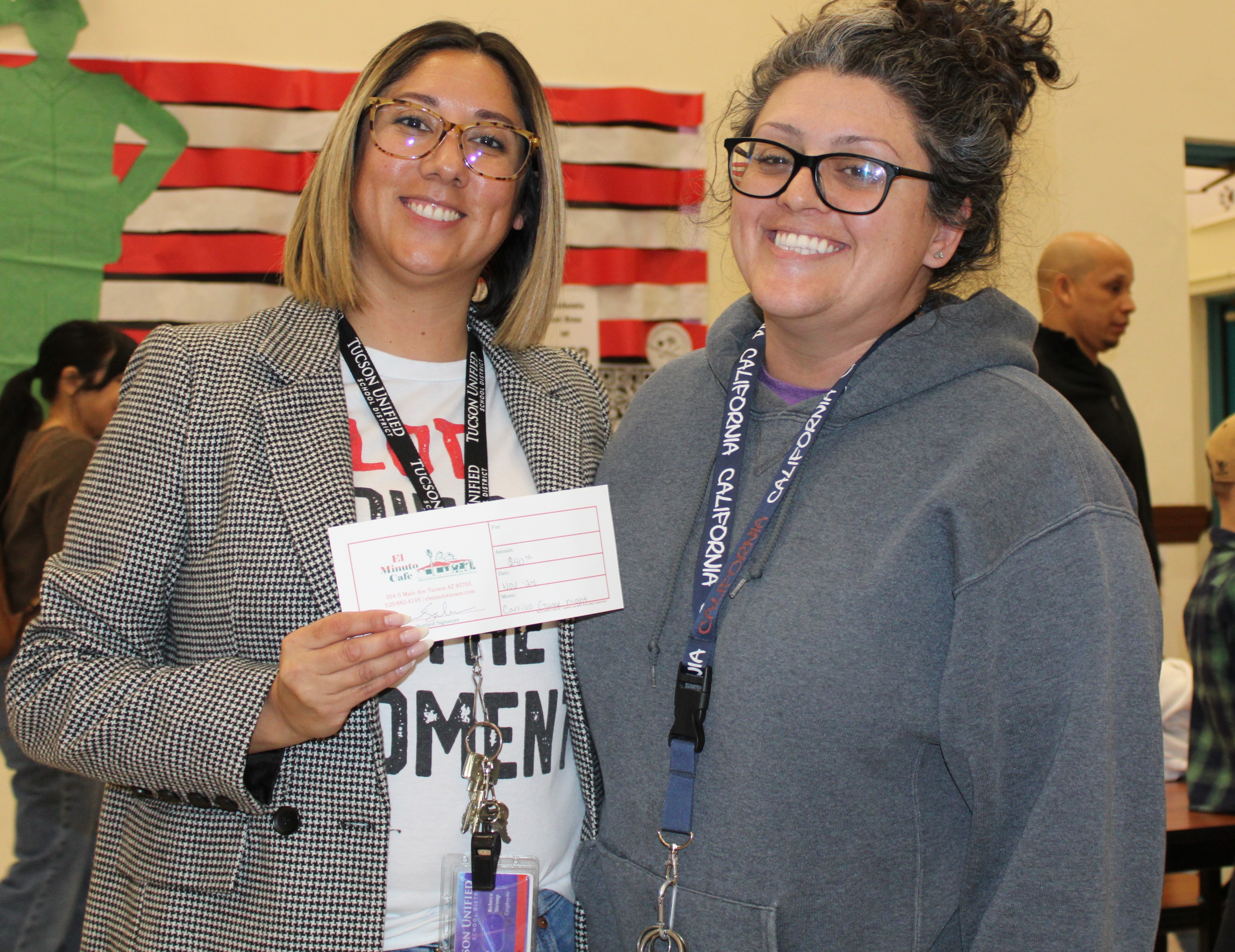 Two women smile with a certificate