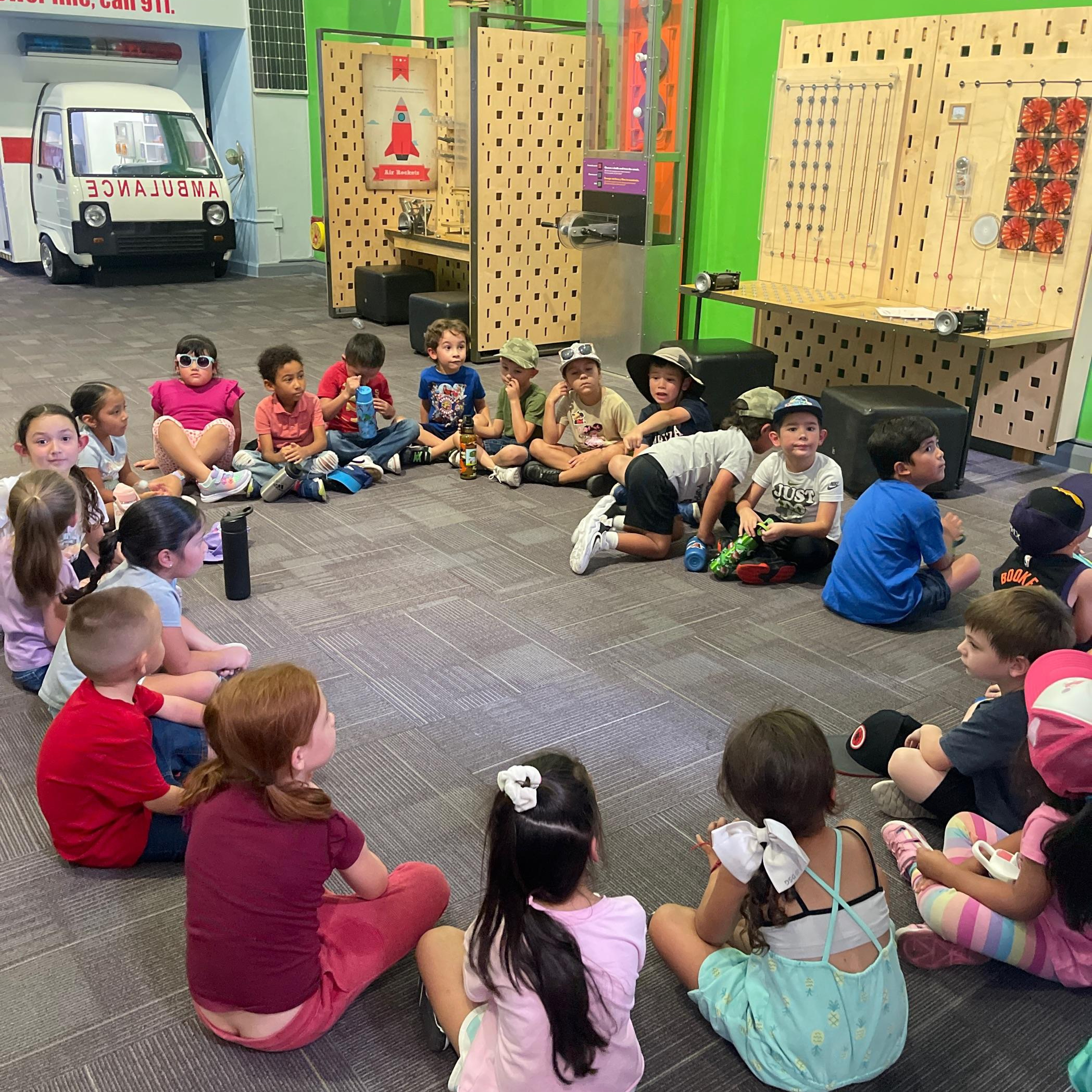 Students sit in a circle on the floor