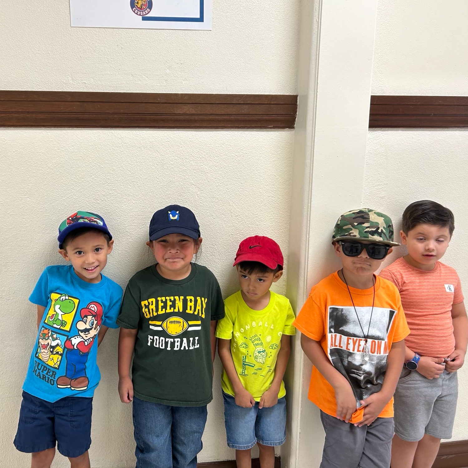 Five boys stand in line smiling