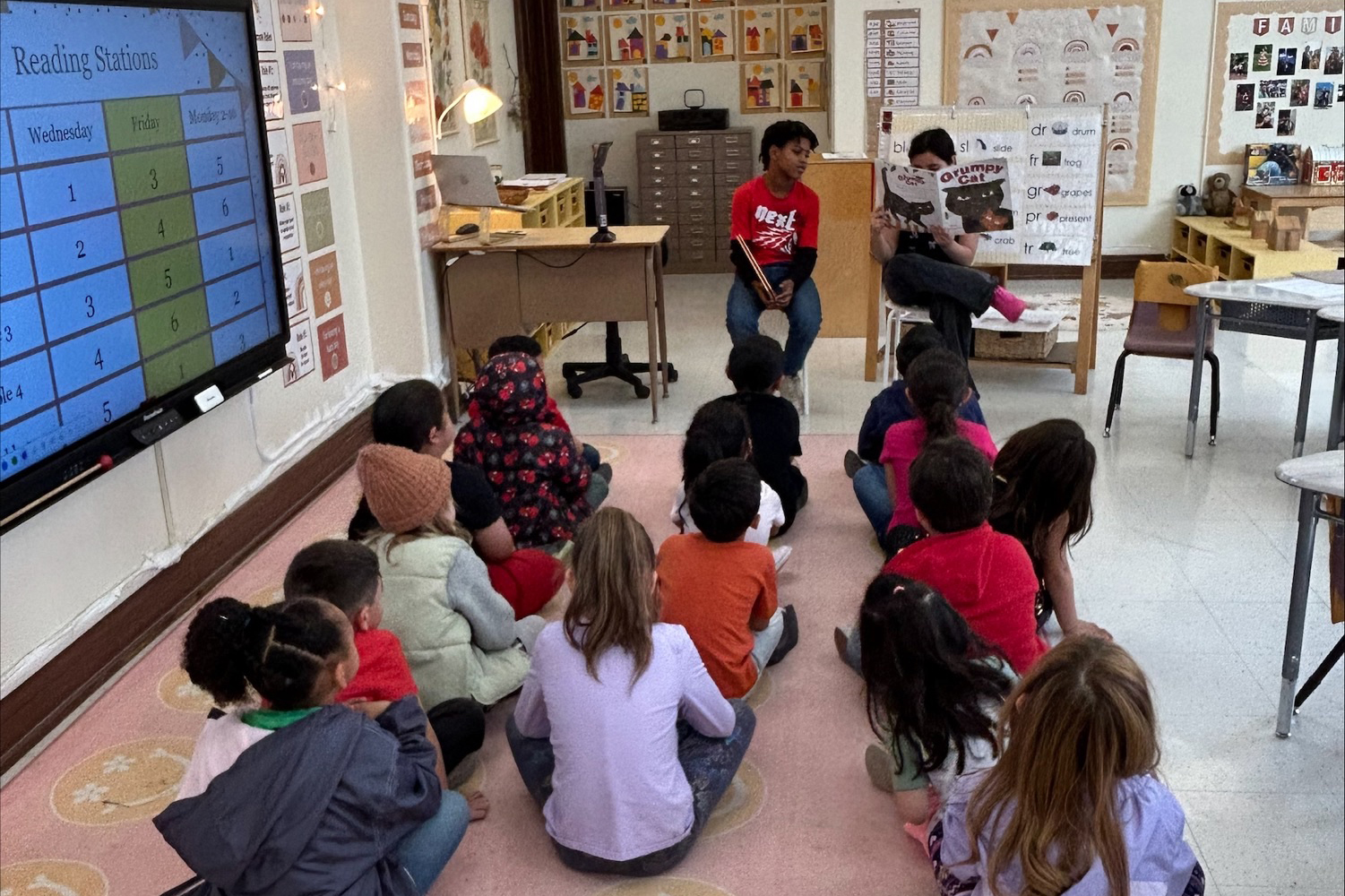 Students sit on the floor listening to a story