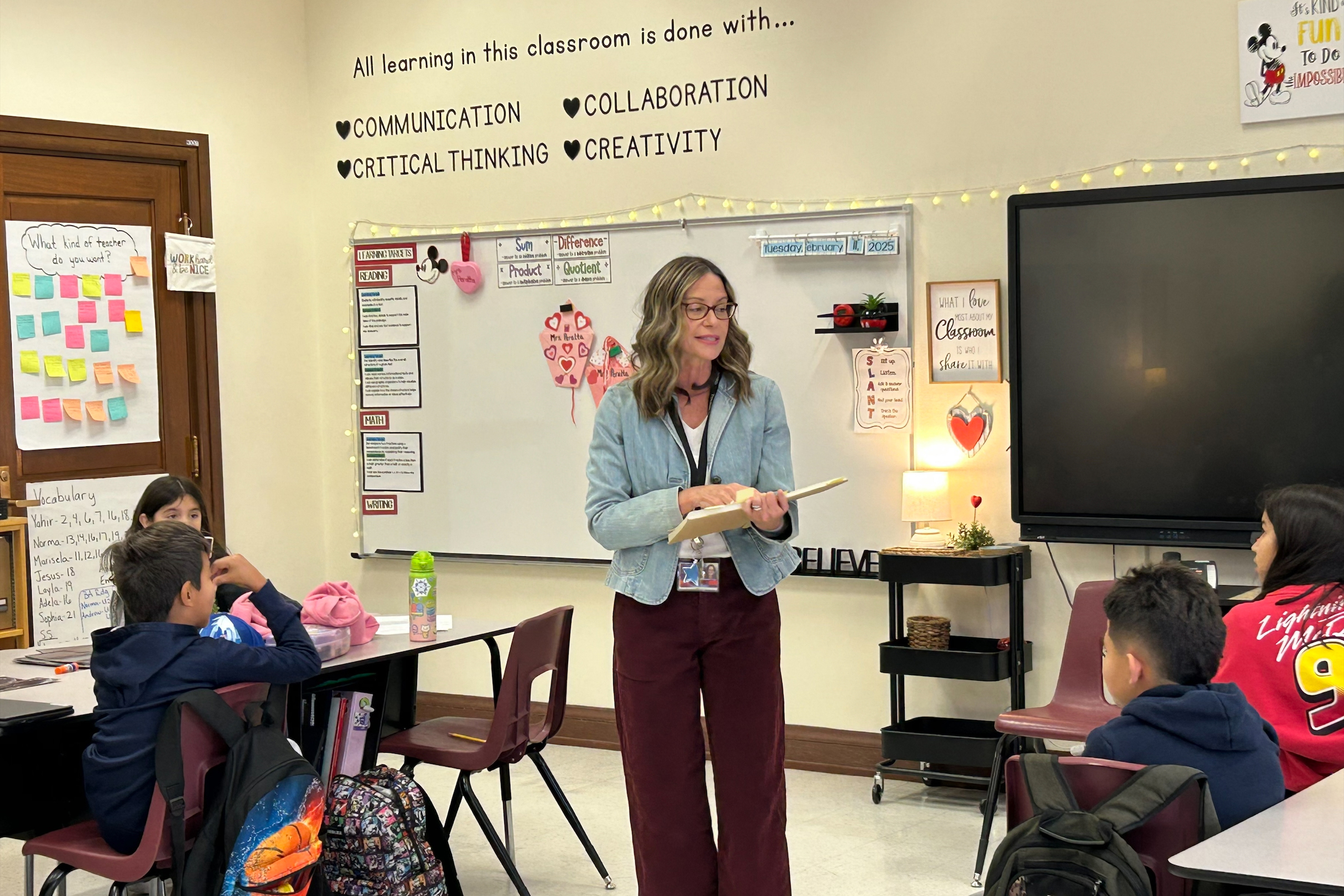 A teacher in glasses reads to her class