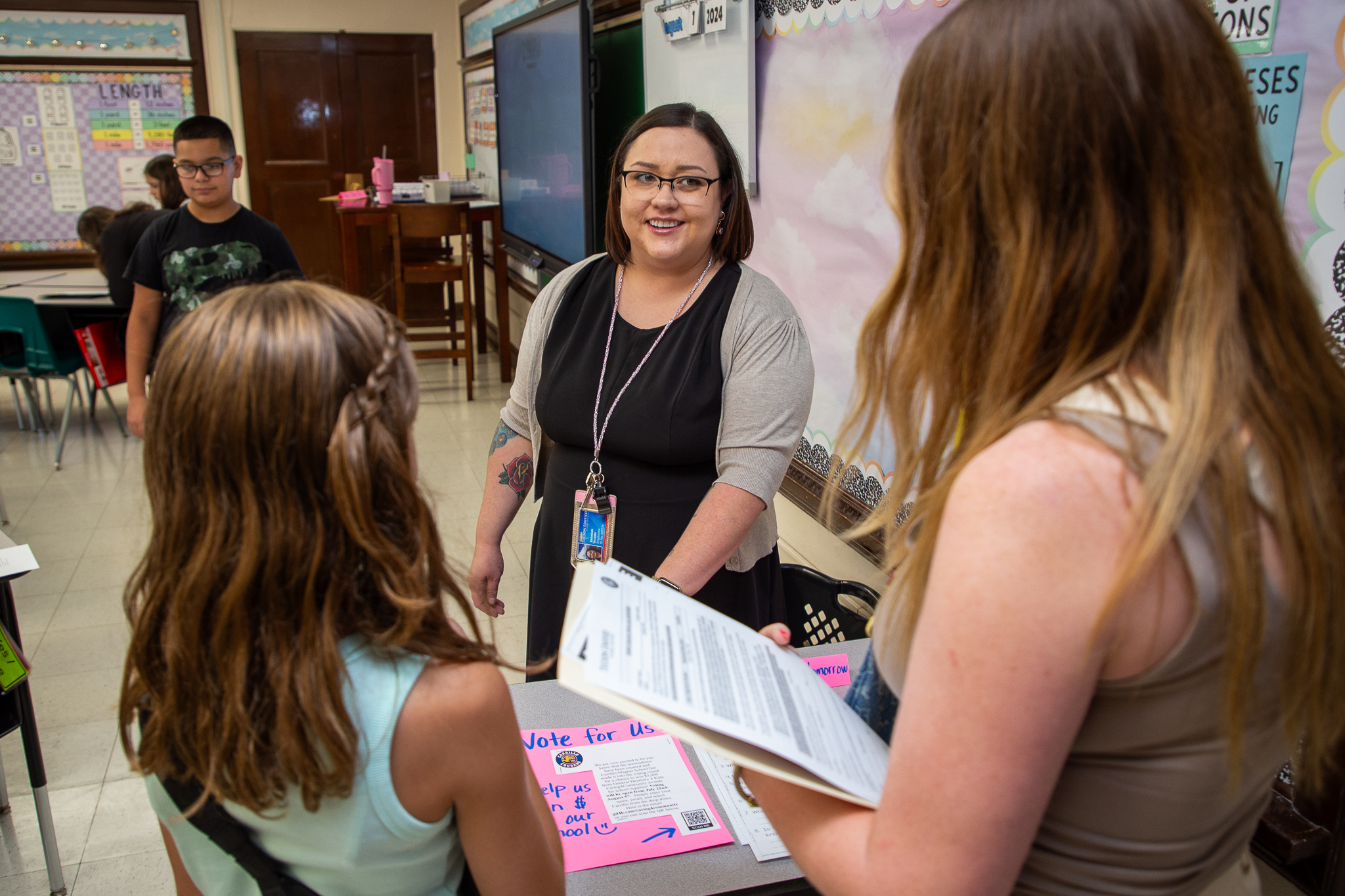 A teacher talks with a student and her mom