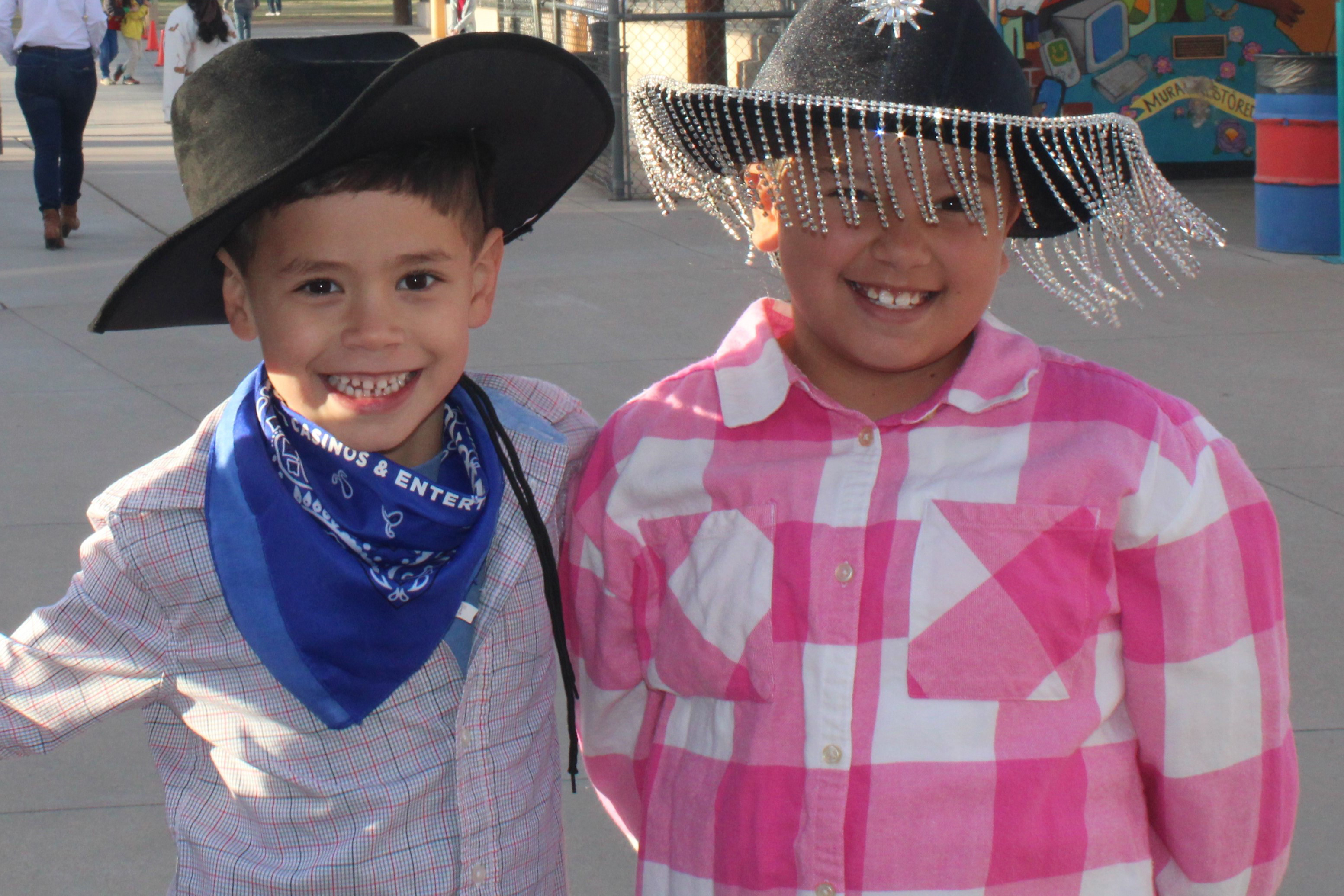 A little boy and little girl smile in their western wear