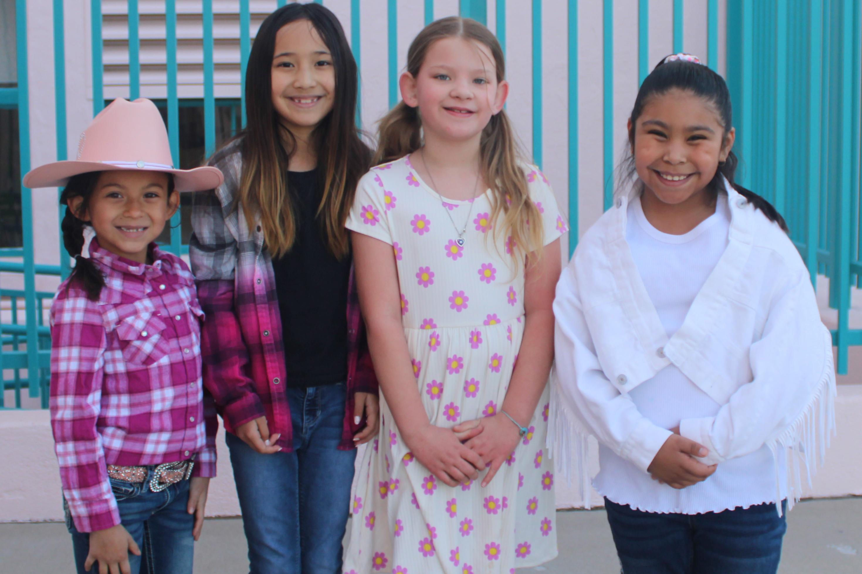 Four girls smile in their western wear