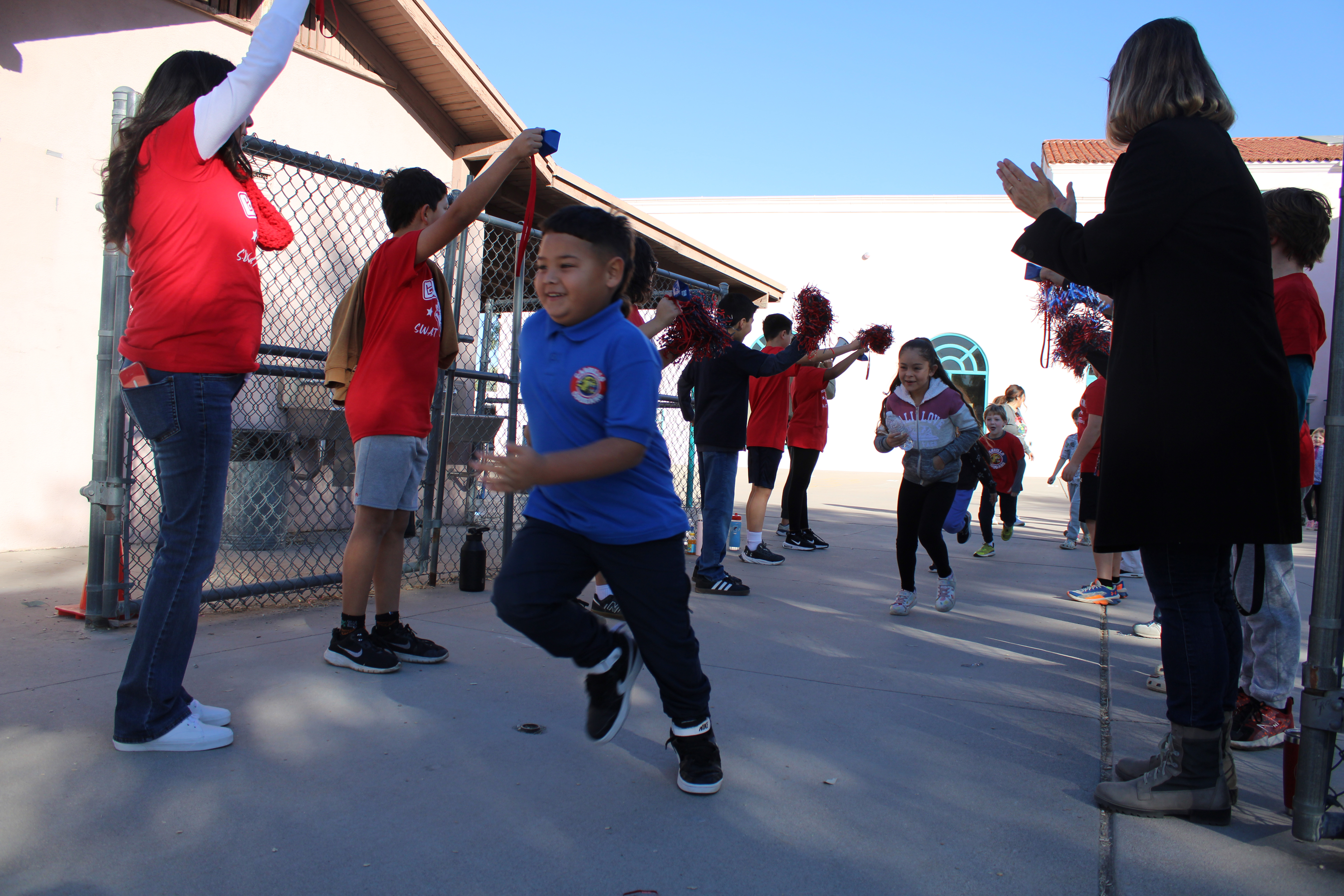 Kids run through a tunnel of supporters 