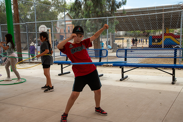 A boy hula hoops outside