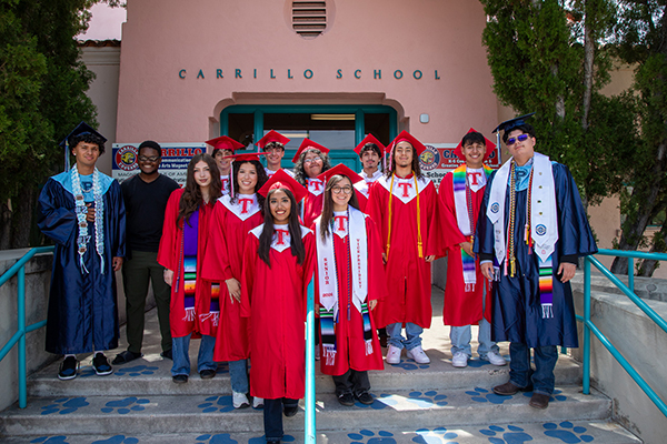 High school grads pose for a group photo outside Carrillo in their caps and gowns