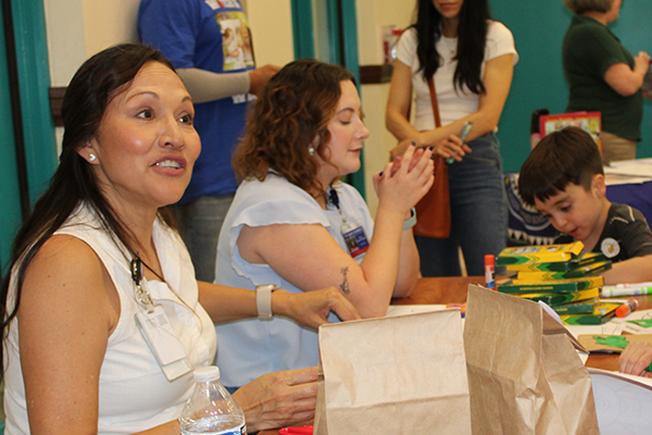 A woman smiles at a student at a table