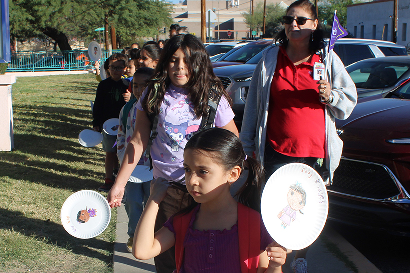 Students hold up their hand drawn signs celebrating Ruby Bridges