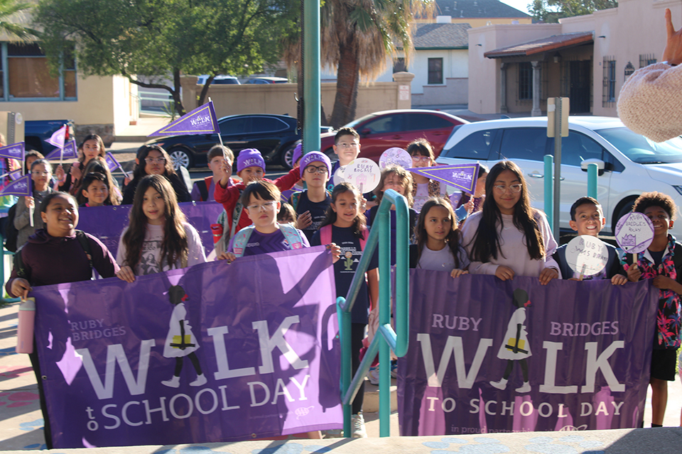 Students march around campus holding purple Ruby Bridges banners