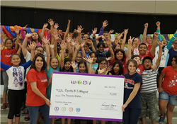 students and teachers holding large check
