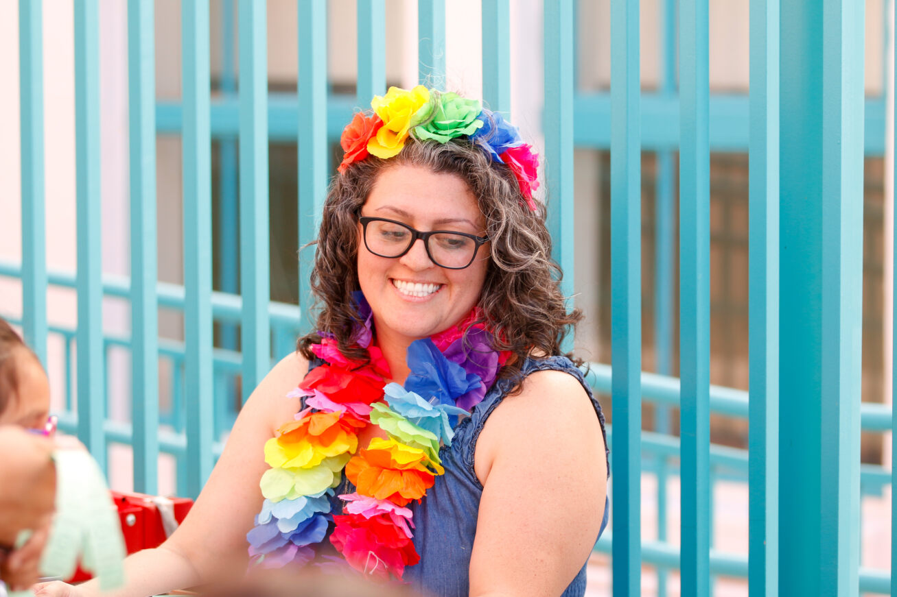 A teacher smiles in her colorful leis