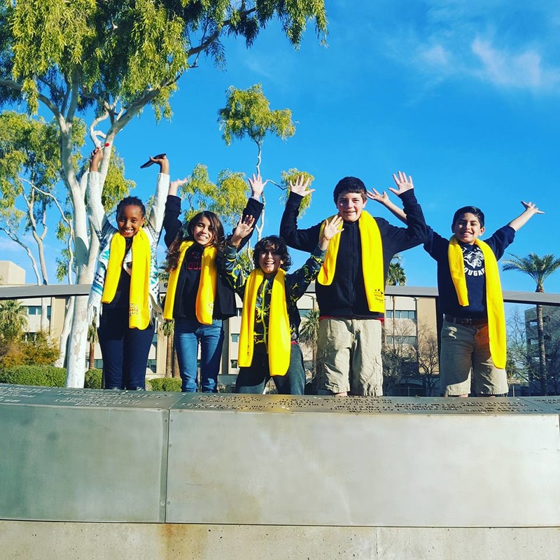 students raising hands in air